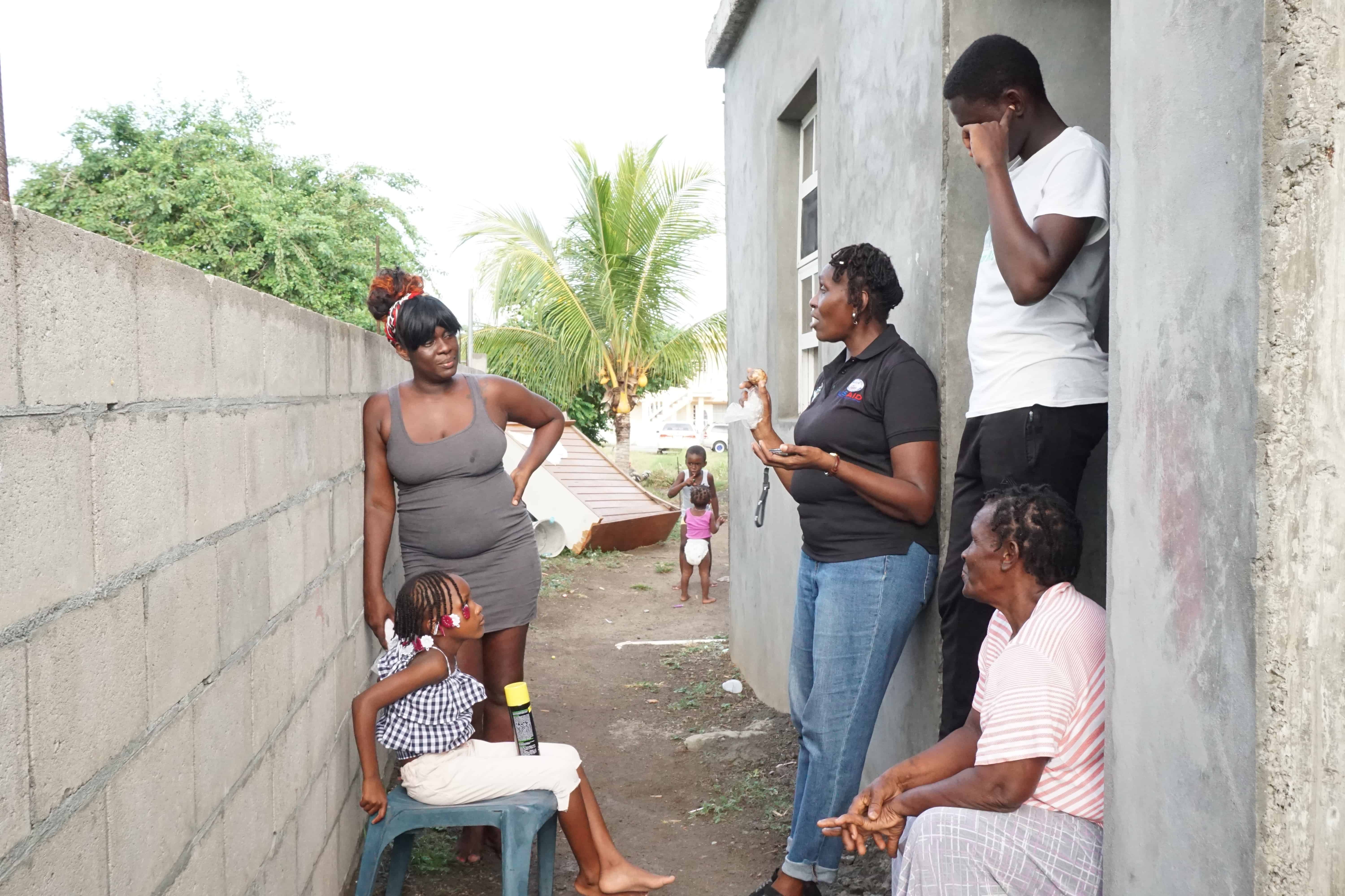 Family-Counselor-in-front-of-house-of-participating-youth-and-family-in-St.-Kitts-and-Nevis-1