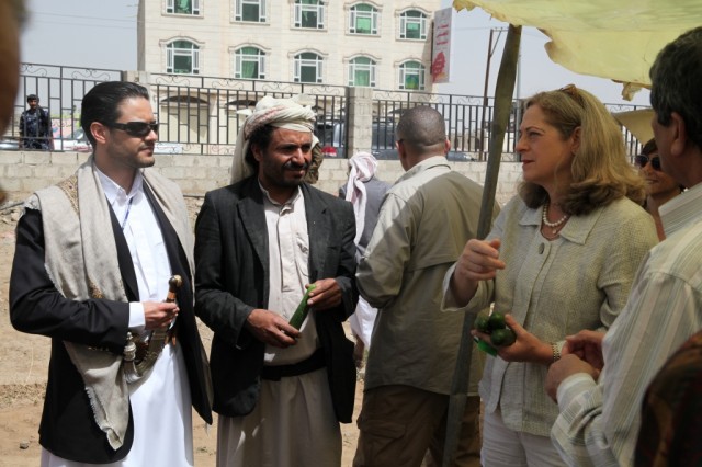 Farmer Khalib Al Humaidi, second from left, gives visiting USAID Assistant Administrator Alina Romanowski sample produce from the Sawan farm.