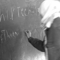 girl writing at chalkboard