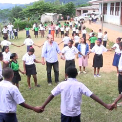 Children and adult holding hands in a circle.