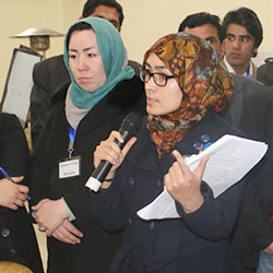 Afghan woman speaking on a microphone.