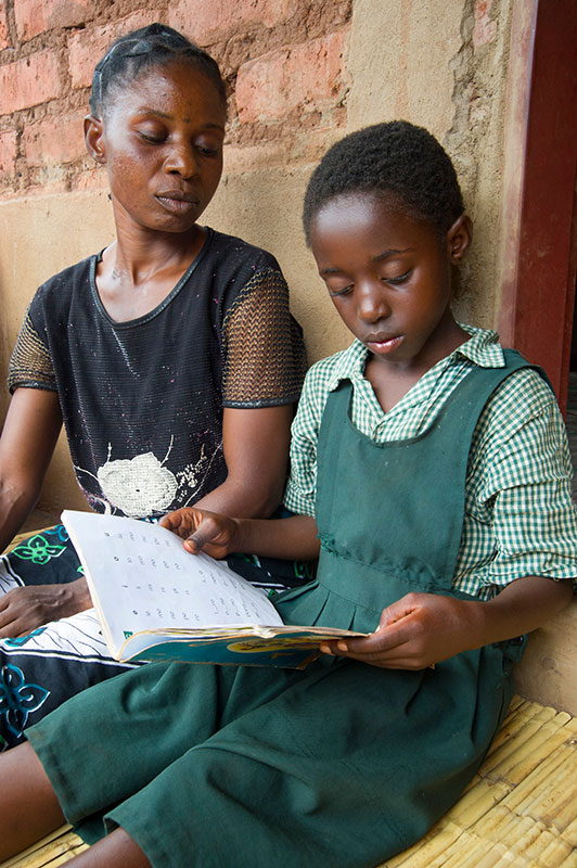 A girl in Chipata, Zambia practices reading with her mother. The impressive results of some pilot reading projects might be replicable at scale, but are not guaranteed.