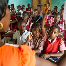 Zambian Girl raising hand in classroom.