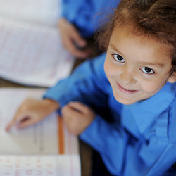 Moroccan girl smiling reading a book.
