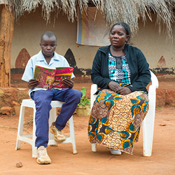 Zambia boy and woman reading a book.
