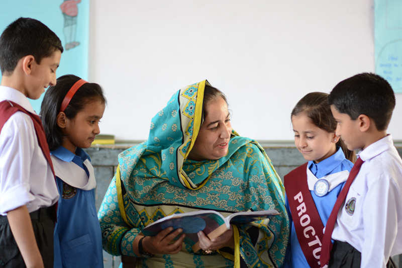 Pakastani teacher reading to students.