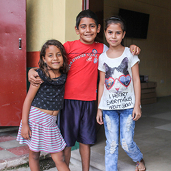 Honduran children hugging and smiling.