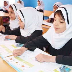 Afghan girls reading books in classroom.