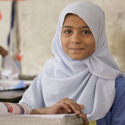 Pakistani girl reading in classroom.