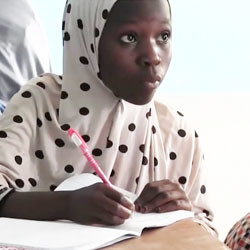 Nigerian girl writing in classroom.