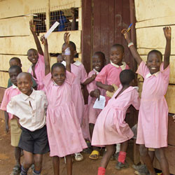 Kampala, Uganda-10 April 2017: Children in pink school uniform in front of their school waving.