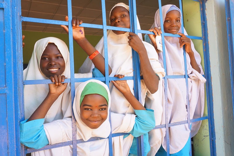 Nigerian girls in window of classroom.