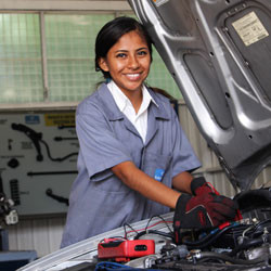 A young Nicaraguan woman works on a car.