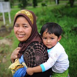 An Indonesian woman carries her son.