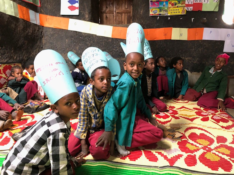 Young Ethiopians sitting on the floor at a reading camp.