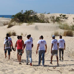 A group of Tunisian youth walk on the beach.