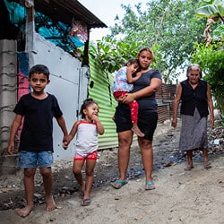 A Honduran woman walks with her family