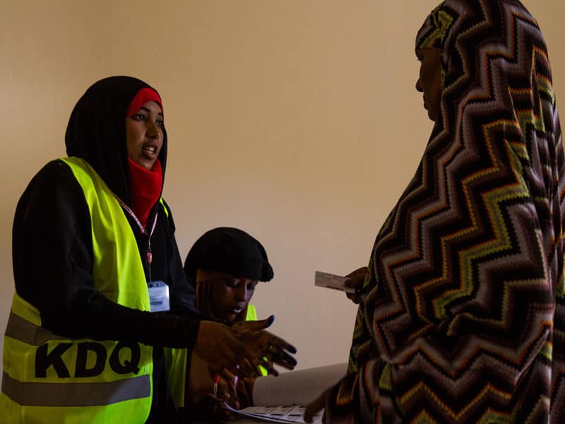 A polling worker registers a woman to vote in Somaliland