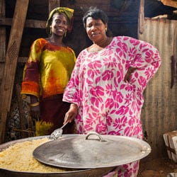 Two Senegalese women cook rice.