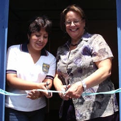 Two women cut the ribbon on an Outreach Center in Guatemala in the early 2000s