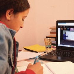 A Moroccan girl takes notes during an online course.