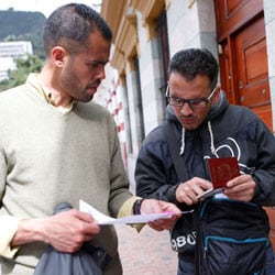 Two Venezuelan men in Colombia look over documents.
