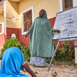 A teacher leads class in at at adolescent girls learning center.